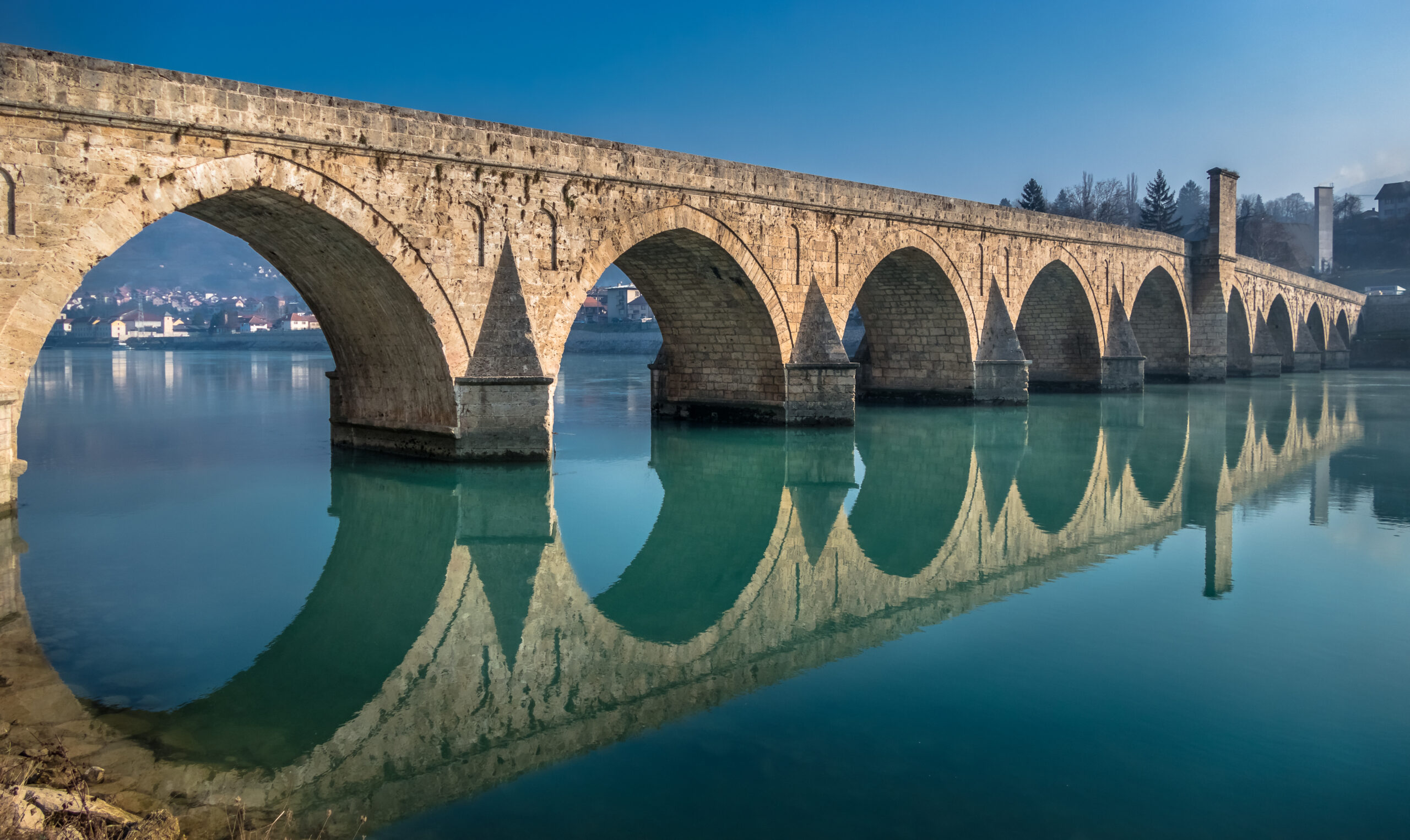 old-arched-bridge-over-water-way-with-a-perfect-calm-mirror-reflection
